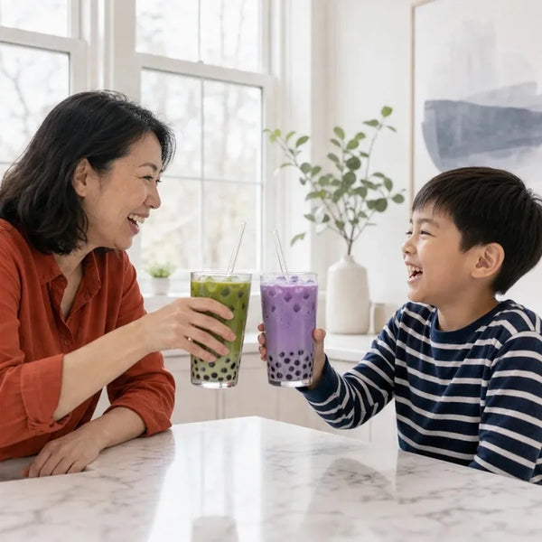 Mom and son toasting matcha and taro boba in the kitchen