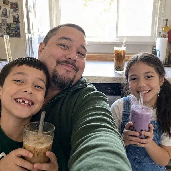 Dad and kids kitchen selfie with boba drinks